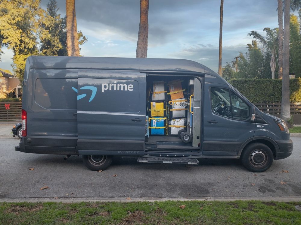 LOS ANGELES, CA - NOVEMBER 2023 Amazon Prime delivery vehicle with side door open and Amazon Fresh boxes piled inside, pictured in city street of West Hollywood.