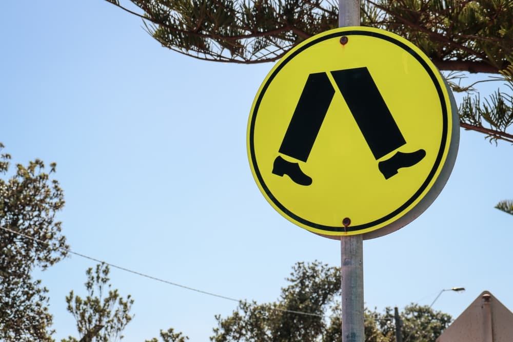 pedestrian crossing sign against blue sky