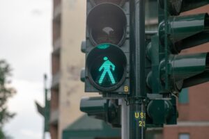 A green pedestrian signal light is illuminated, indicating it is safe for pedestrians to cross the street.