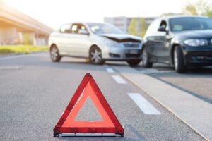 Reflective red triangle signals car crash scene, highlighting urgency and need for a car accident lawyer.