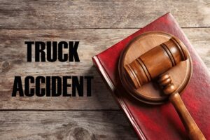 Truck accident law. Judge's gavel and book on wooden table, top view