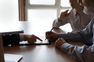 Car accident lawyer guides elderly clients through settlement paperwork.