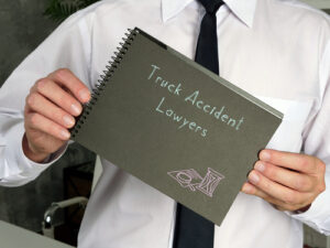 Person holding a notebook with the words truck accident lawyers written on the cover